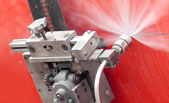 Mit der Wasser-Abrasiv- Suspension-Schneidtechnik wird mit Wasserhochdruck ein rotes Material durchtrennt.